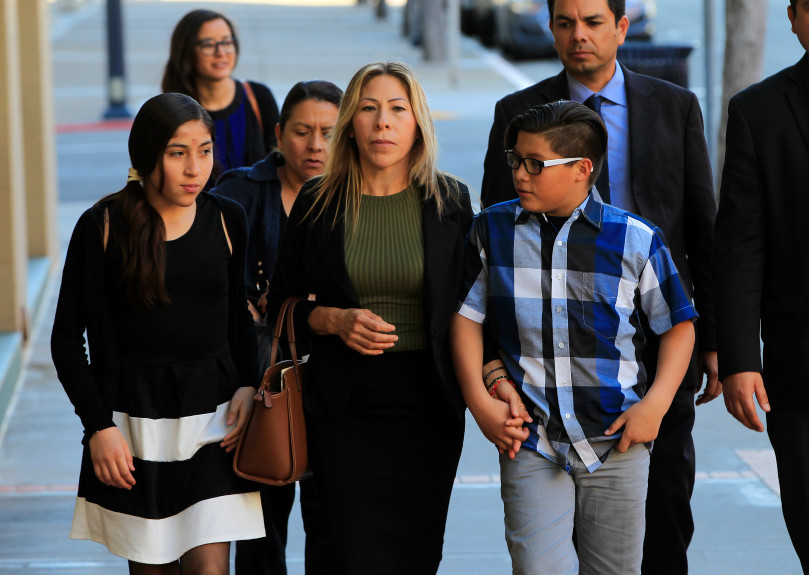 With their supporters, Maria Puga, center, arrives with her children to a news conference on Thursday, March 2, 2017, in San Diego, Calif. A federal judge tentatively approved an agreement Thursday for the U.S. government to pay $1 million to the children of Anastasio Hernandez, a Mexican man who died after being detained by immigration authorities and shot several times with a stun gun. Puga was Hernandez's longtime partner and the mother of their five children. (Eduardo Contreras/The San Diego Union-Tribune via AP)