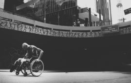 grayscale photo of man on wheelchair