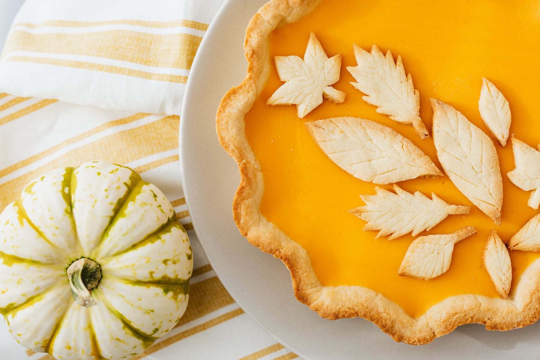 baked pumpkin pie with decorative leafy patterns design