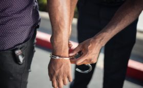 police officer putting handcuffs on another person